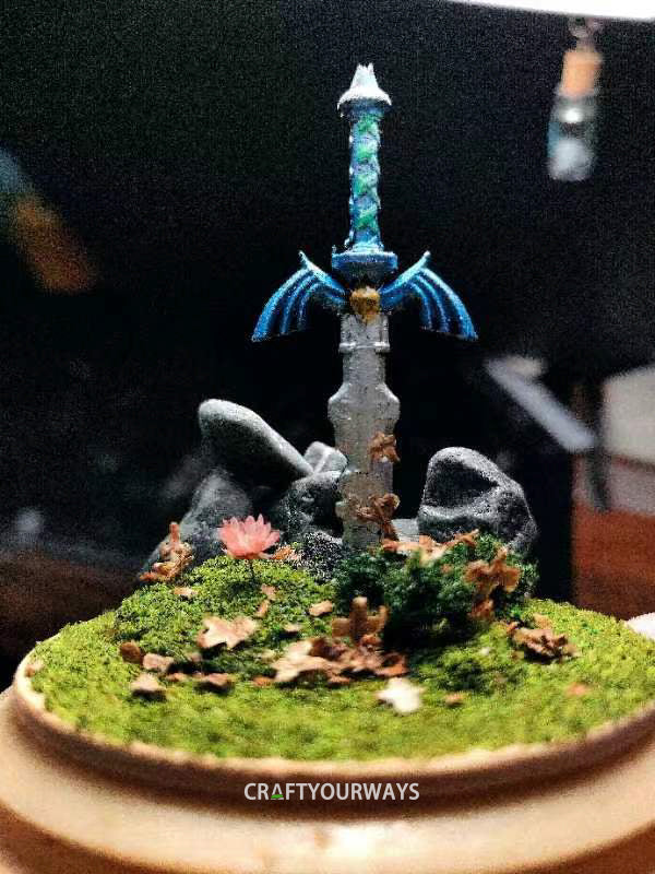 Miniature Scene of a Sword Stuck in Grass