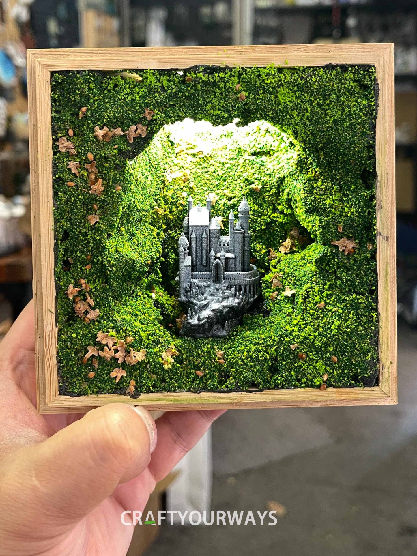 Miniature Castle in Illuminated Cave with Greenery in Wooden Box