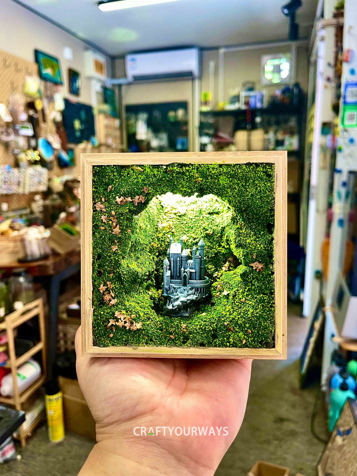 Miniature Castle in Illuminated Cave with Greenery in Wooden Box