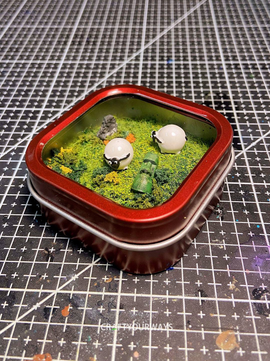 Miniature Resurrected Figure with Grazing Sheep in Tin Box